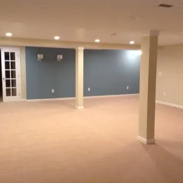 Finished basement room with a blue accent wall, carpet, and recessed lighting